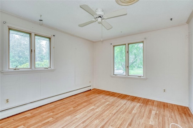 spare room with a baseboard heating unit, wood finished floors, ornamental molding, a ceiling fan, and baseboards