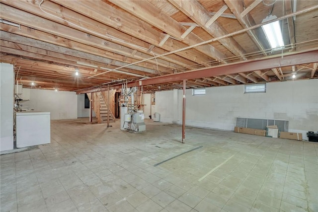 basement with stairway, washer / dryer, and tile patterned floors