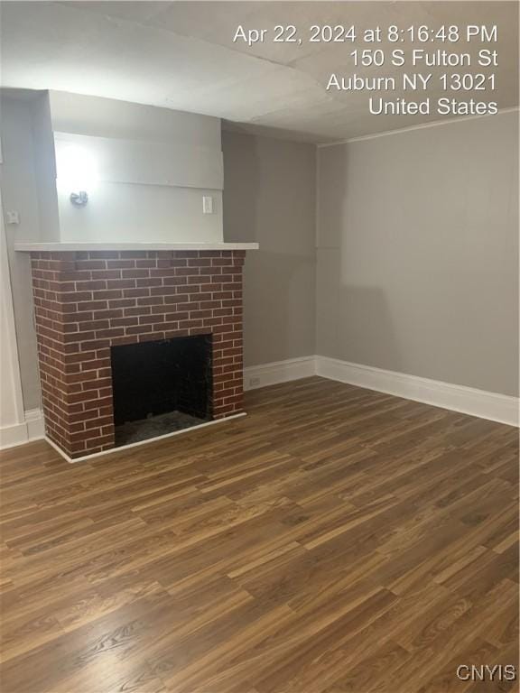 unfurnished living room featuring baseboards, a fireplace, and wood finished floors