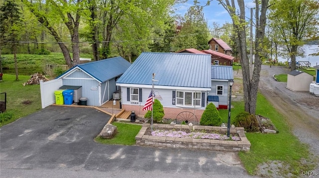 21 S Lake Rd, Deruyter, NY 13052 - view of front facade with asphalt driveway, brick siding, metal roof, and a front yard