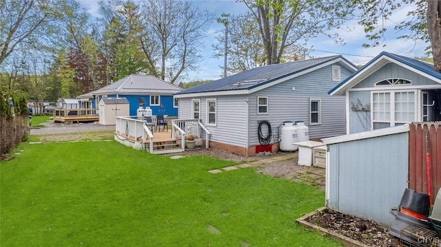 21 S Lake Rd, Deruyter, NY 13052 - back of house with a wooden deck, a lawn, and metal roof