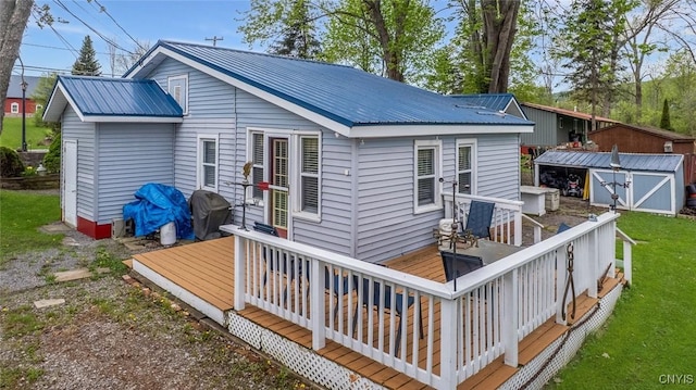 21 S Lake Rd, Deruyter, NY 13052 - rear view of property featuring a storage unit, metal roof, a deck, an outbuilding, and a lawn