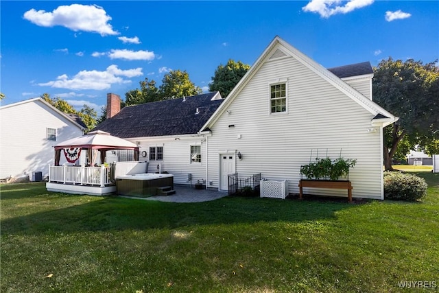 rear view of house with a gazebo, a hot tub, a yard, a patio area, and cooling unit