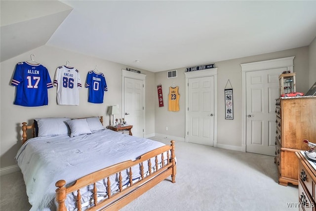 bedroom featuring light colored carpet and baseboards