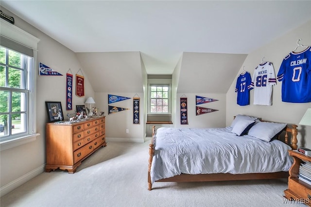 bedroom featuring vaulted ceiling, light carpet, and baseboards