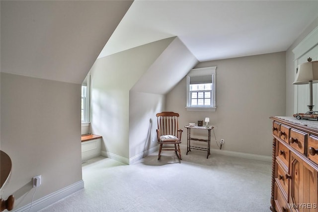 living area featuring carpet, baseboards, and lofted ceiling