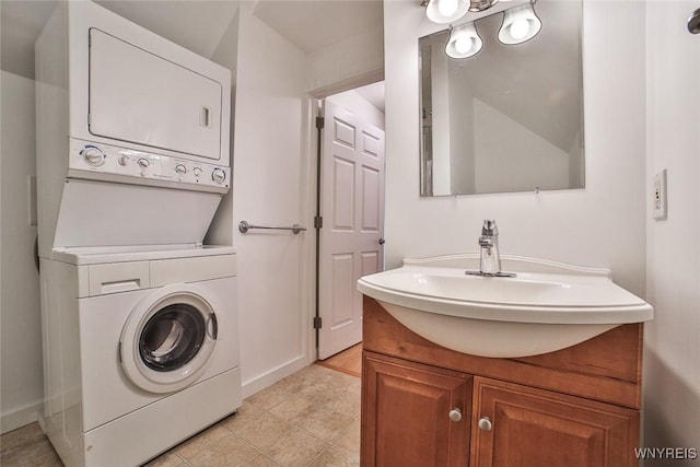 laundry area featuring stacked washer / drying machine and baseboards