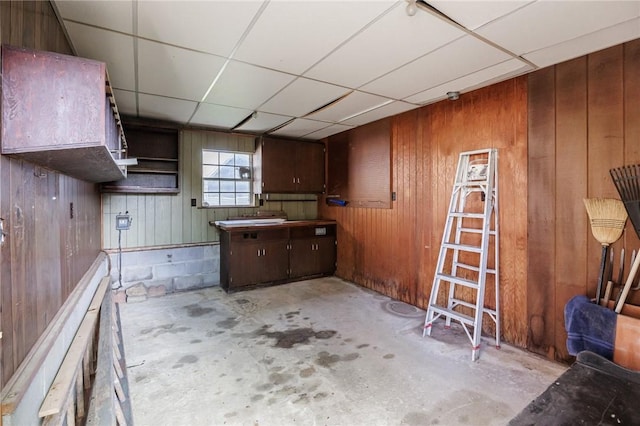 89 Chapel St, Mount Morris, NY 14510 - kitchen with unfinished concrete flooring, wooden walls, and a paneled ceiling
