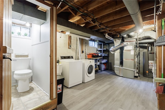 164 Elm Dr, Rochester, NY 14609 - below grade area featuring gas water heater, washer and dryer, heating unit, wood finished floors, and healthy amount of natural light