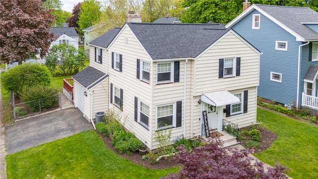 164 Elm Dr, Rochester, NY 14609 - view of front of home with a chimney, a shingled roof, a garage, and central AC