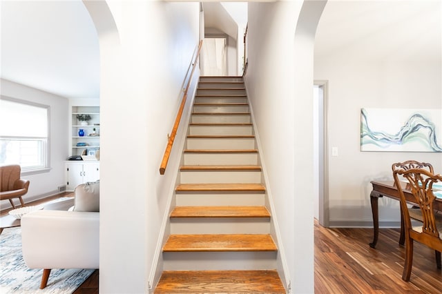 164 Elm Dr, Rochester, NY 14609 - stairs with arched walkways, wood finished floors, and baseboards