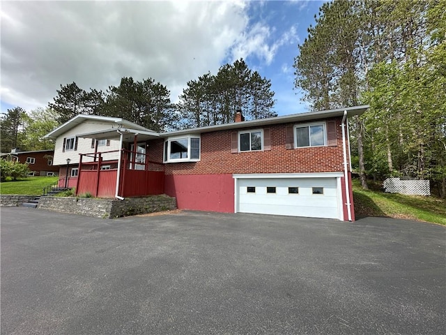 22 Suncrest Ter, Oneonta-City, NY 13820 - view of front facade featuring asphalt driveway, brick siding, a garage, and a chimney
