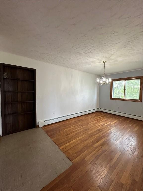 22 Suncrest Ter, Oneonta-City, NY 13820 - empty room featuring a chandelier, wood-type flooring, a textured ceiling, baseboard heating, and a baseboard radiator
