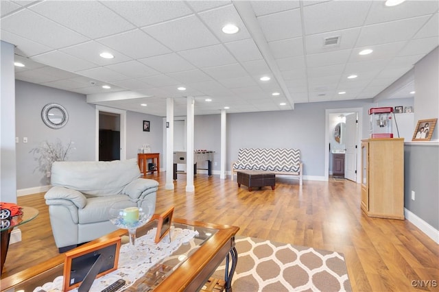 living room featuring baseboards, light wood-style floors, and recessed lighting