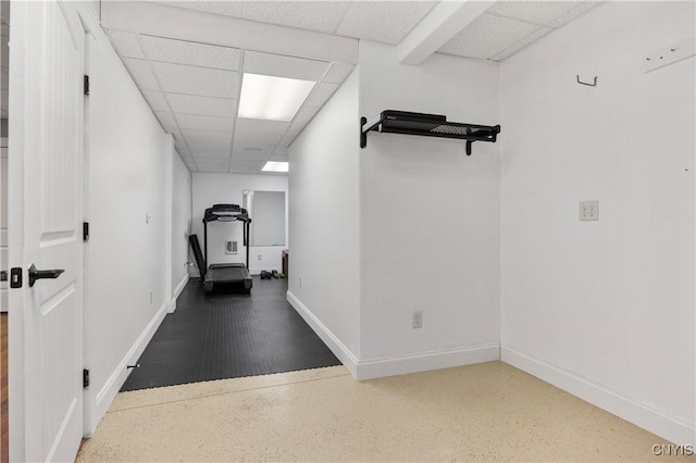 workout room with a drop ceiling and baseboards