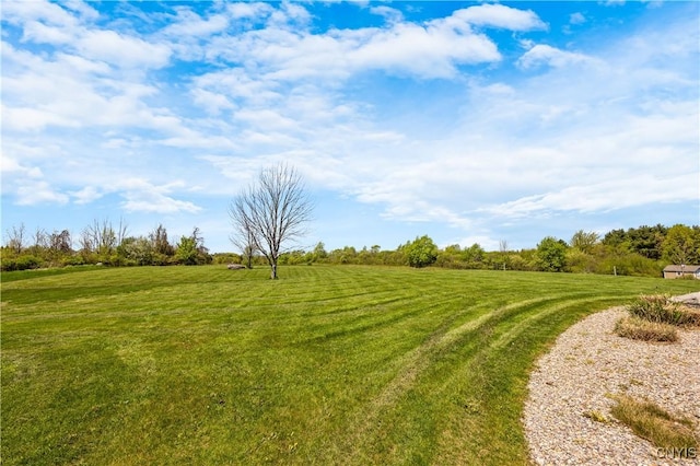 surrounding community featuring a view of countryside and a yard