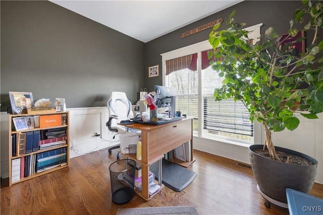office area with healthy amount of natural light, wainscoting, and wood finished floors
