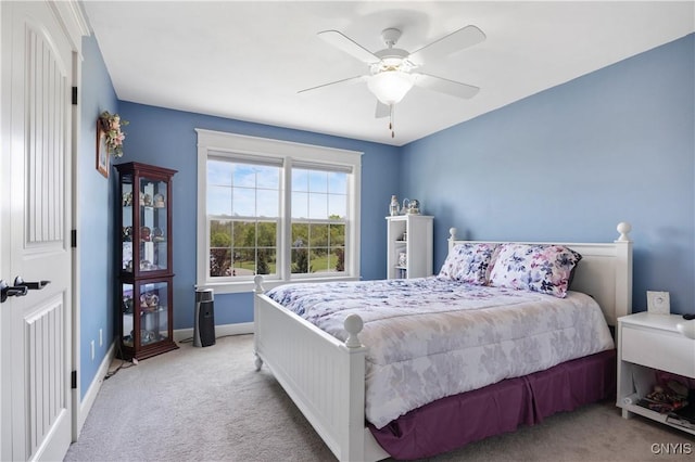 bedroom with light carpet, baseboards, and a ceiling fan