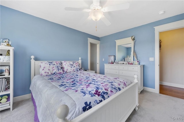 bedroom with light colored carpet, baseboards, and ceiling fan