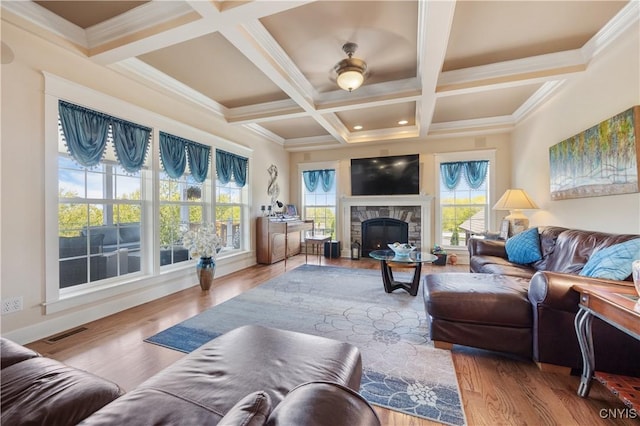living area with a stone fireplace, beamed ceiling, wood finished floors, and coffered ceiling