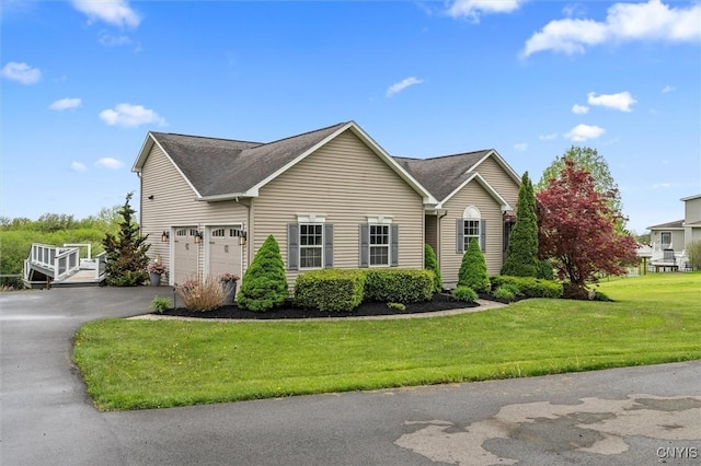 view of front facade featuring asphalt driveway, an attached garage, and a front lawn