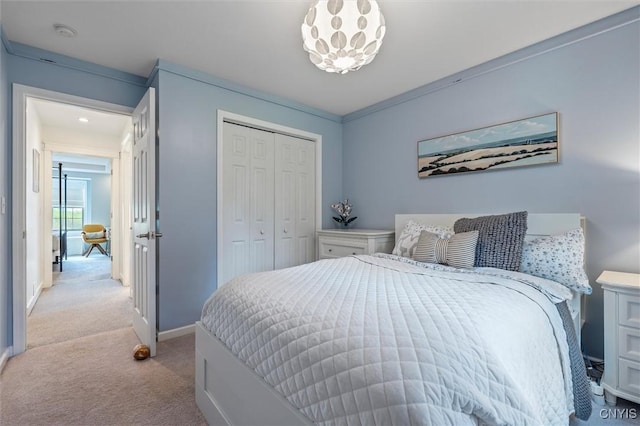 bedroom featuring light carpet, a closet, and baseboards