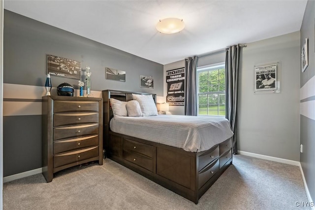 bedroom featuring light colored carpet and baseboards