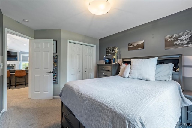 bedroom with light carpet, a closet, and baseboards
