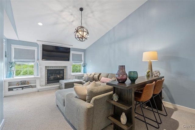 living room featuring carpet floors, a chandelier, lofted ceiling, a tiled fireplace, and baseboards