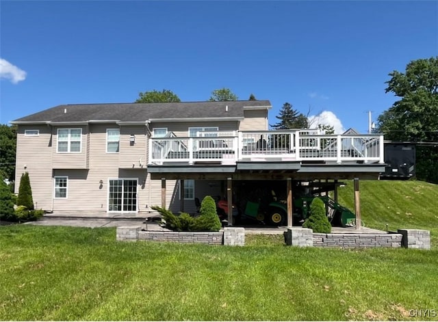 rear view of property featuring a deck, a lawn, and a patio area