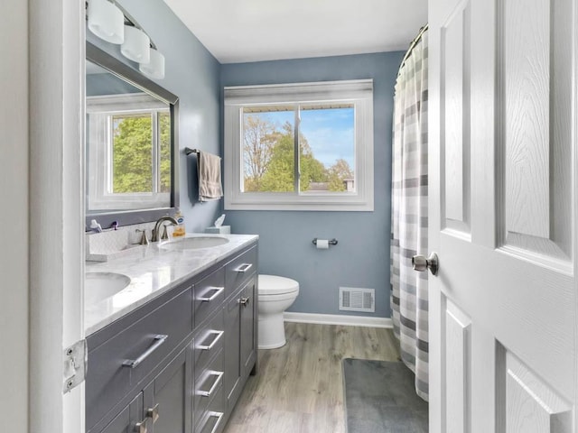 163 Lyncourt Park, Greece, NY 14612 - bathroom with toilet, double vanity, wood finished floors, and baseboards