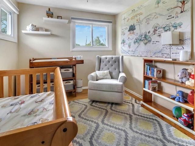 163 Lyncourt Park, Greece, NY 14612 - bedroom featuring multiple windows, wood finished floors, a crib, and baseboards