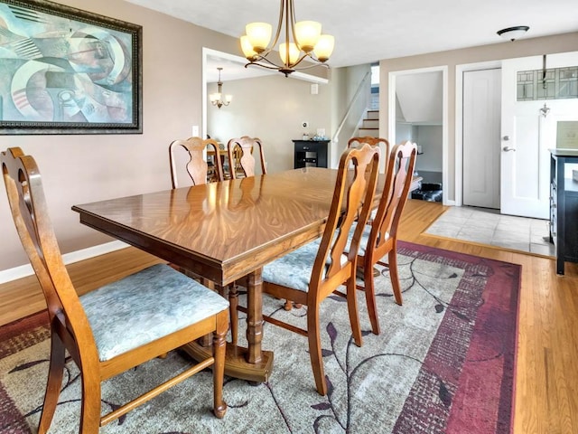 163 Lyncourt Park, Greece, NY 14612 - dining room featuring light wood-type flooring, stairs, a chandelier, and baseboards