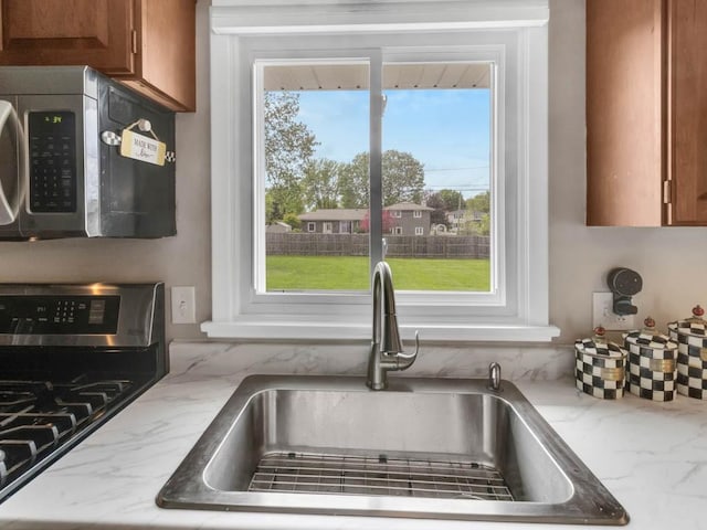 163 Lyncourt Park, Greece, NY 14612 - kitchen featuring stainless steel appliances, a sink, healthy amount of natural light, and brown cabinets