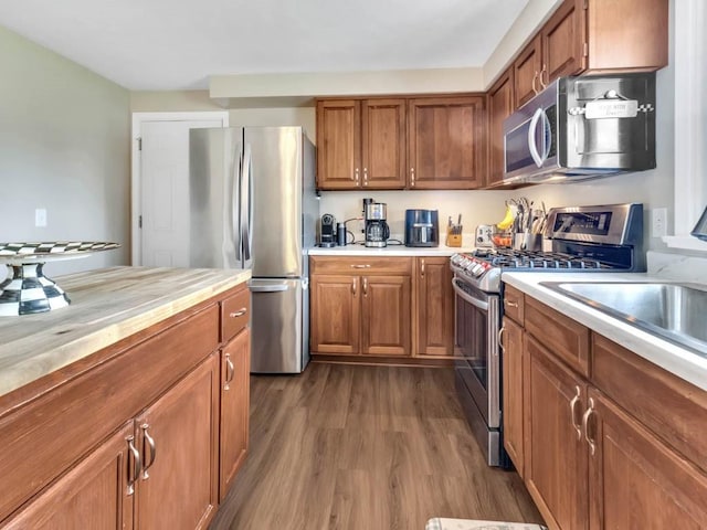 163 Lyncourt Park, Greece, NY 14612 - kitchen featuring appliances with stainless steel finishes, dark wood-style flooring, and brown cabinets