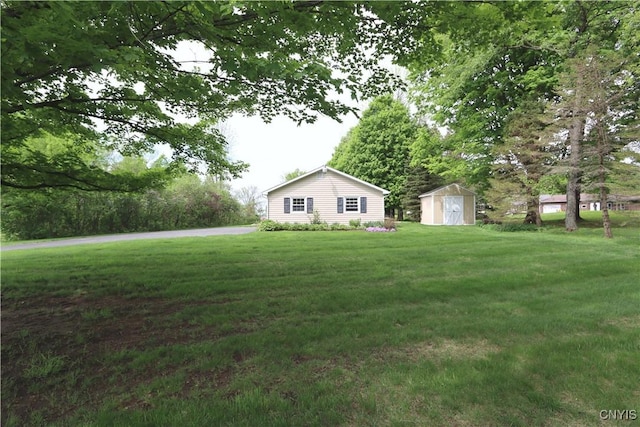 view of grassy yard with a storage shed and an outbuilding