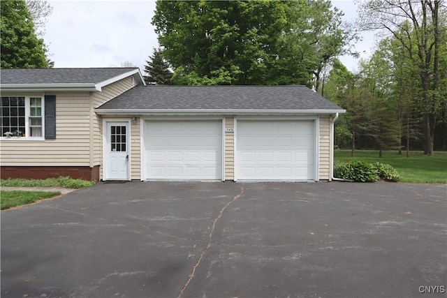 garage featuring asphalt driveway