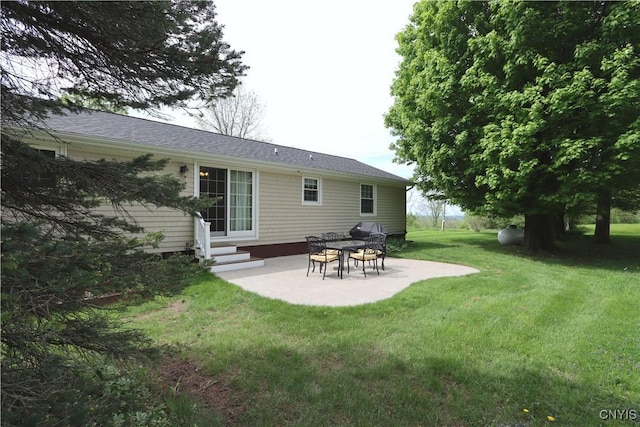 back of property featuring entry steps, a patio, and a yard