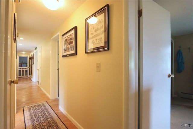 hallway with light tile patterned flooring and a baseboard heating unit