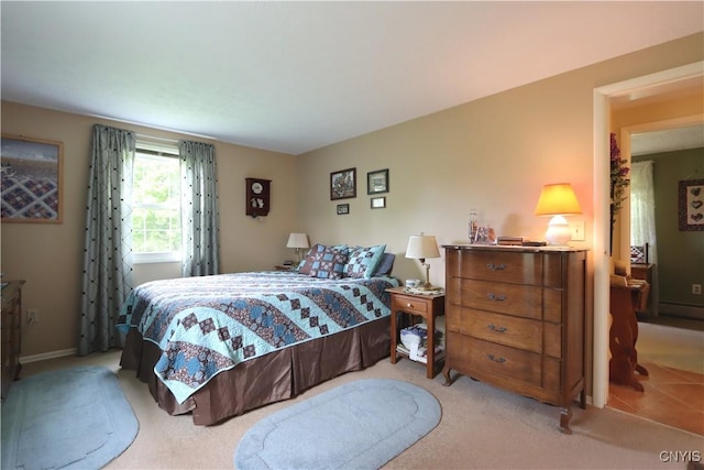 bedroom featuring light carpet and a baseboard heating unit