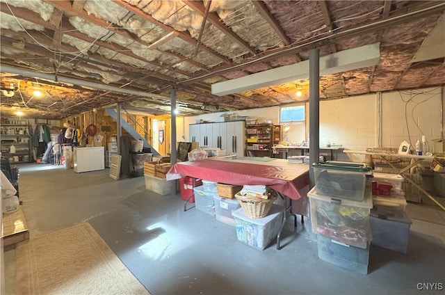 unfinished below grade area featuring washer / dryer and stairway