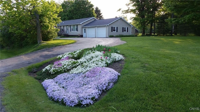 view of front of home with an attached garage, driveway, and a front lawn