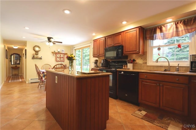 kitchen featuring black appliances, a sink, baseboard heating, light tile patterned flooring, and recessed lighting