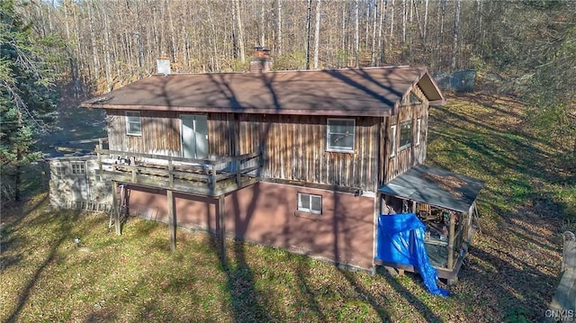 419 Glenwood Ln, Niles, NY 13021 - rear view of house with a chimney, a view of trees, and a lawn