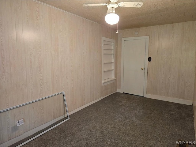 2282 Rte 305, Clarksville, NY 14727 - spare room featuring wooden walls, dark colored carpet, a ceiling fan, and baseboards