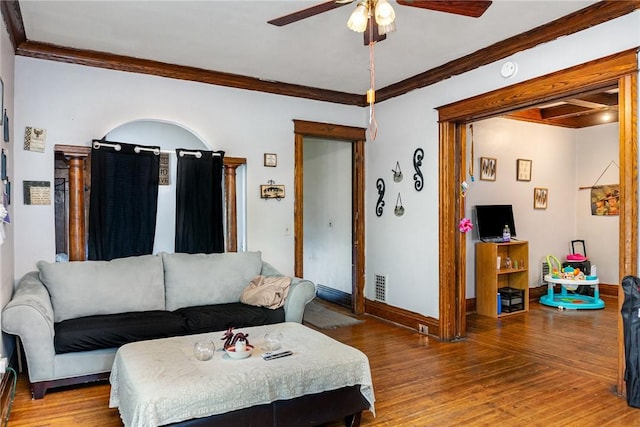 living area featuring a ceiling fan, light wood-style floors, ornamental molding, and baseboards