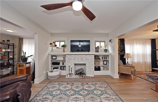 3912 Seneca St Unit 1, West Seneca, NY 14224 - living room featuring a ceiling fan, a brick fireplace, wood finished floors, and baseboards