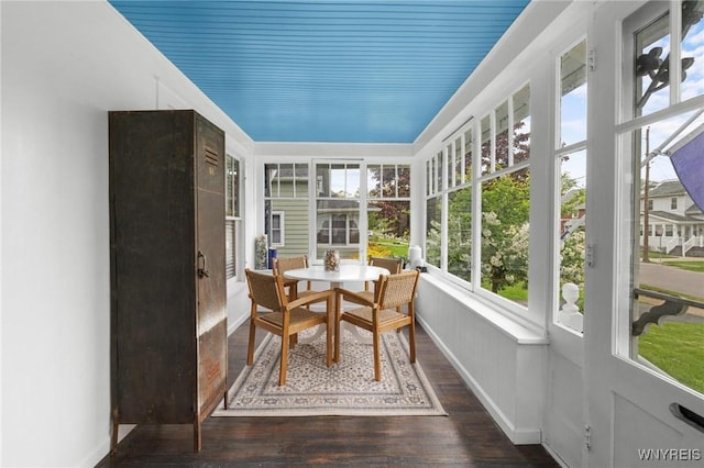 sunroom with wood finished floors and baseboards