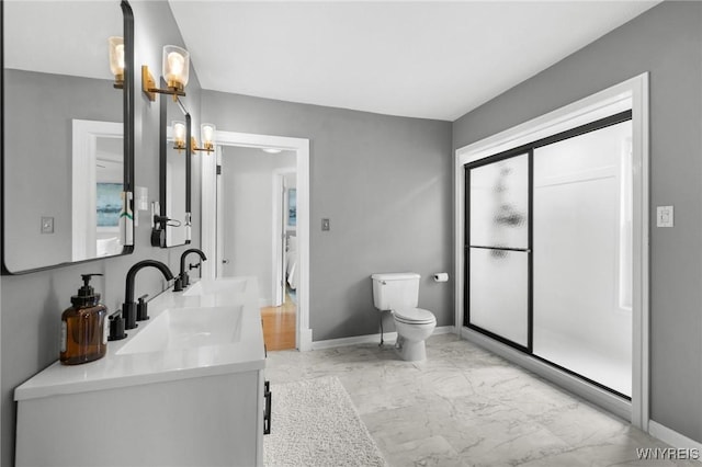 full bath with marble look tiles, toilet, baseboards, and double vanity
