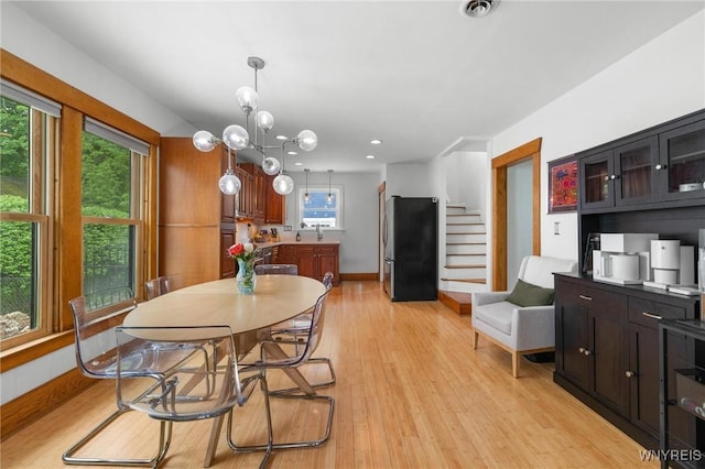 dining space with light wood-style flooring, stairs, baseboards, and recessed lighting